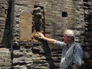 Так называемый "смелый камень" с каменной статуей божественного правителя места оберегают от нечисти. Фото Т.Ян.